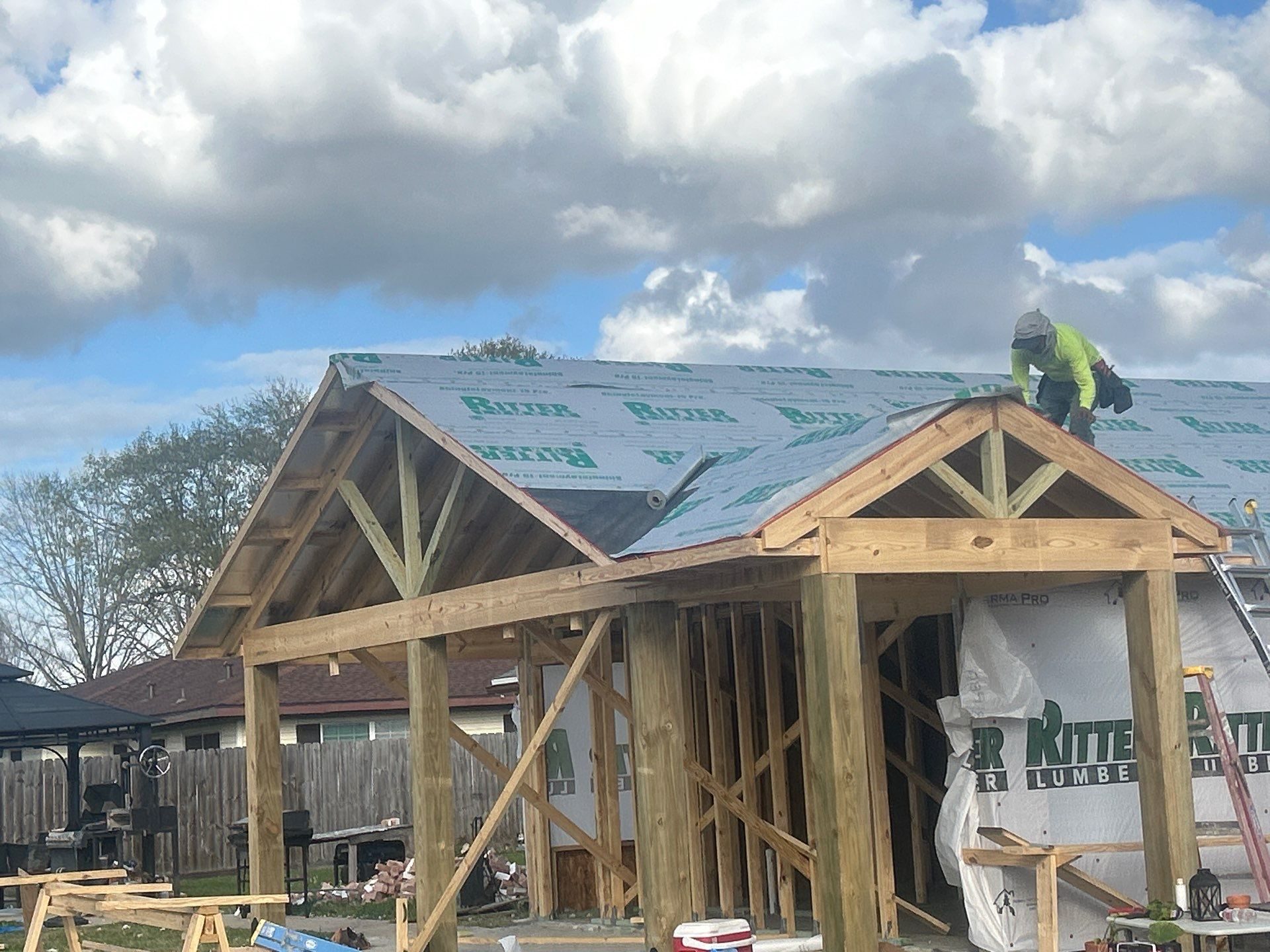 New patio cover under construction with roof underlayment going on